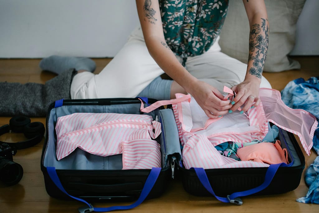 A woman pack for surgery abraod on the floor indoors.